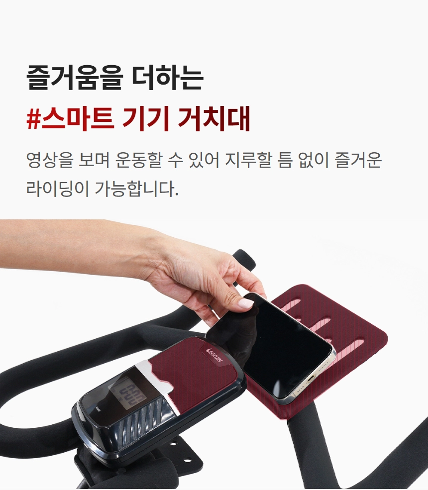 이고진 EGOJIN 이고진 실내 자전거 핸들바에 스마트폰을 거치하는 손의 모습으로, 운동 중 영상 시청을 통해 즐거움을 더해주는 스마트 기기 거치대의 편의성을 보여줍니다.