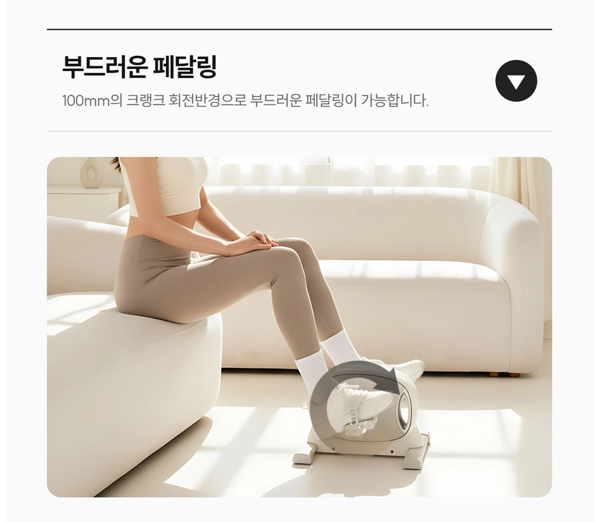 이고진 EGOJIN 이고진 미니 페달 운동기를 이용해 거실 소파에 앉아 100mm 크랭크 회전반경으로 부드럽게 하체 운동을 하는 여성의 모습.